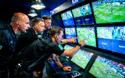 世界杯VAR视频助理裁判工作场景 - 裁判组在监控屏幕前认真查看比赛回放